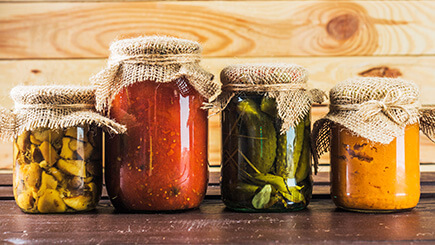 Jars of various canned sauces and vegetables