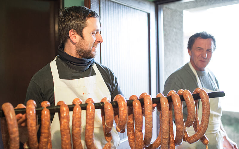 Father and son carrying homemade sausages