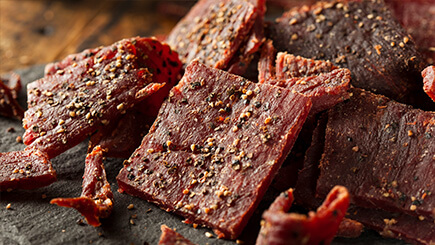 Seasoned jerky on a cutting board