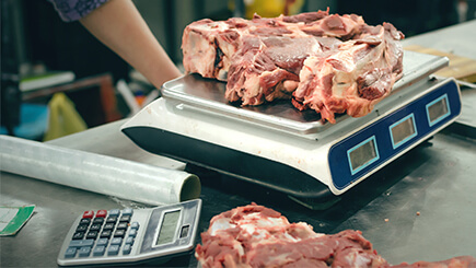 Various chunks of meat being weighed on a scale