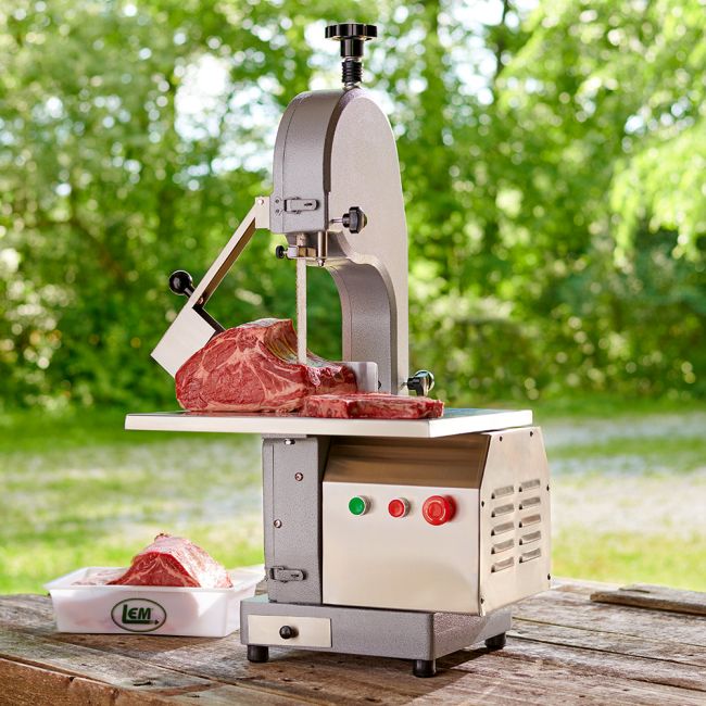 electric meat saw cutting meat on a table