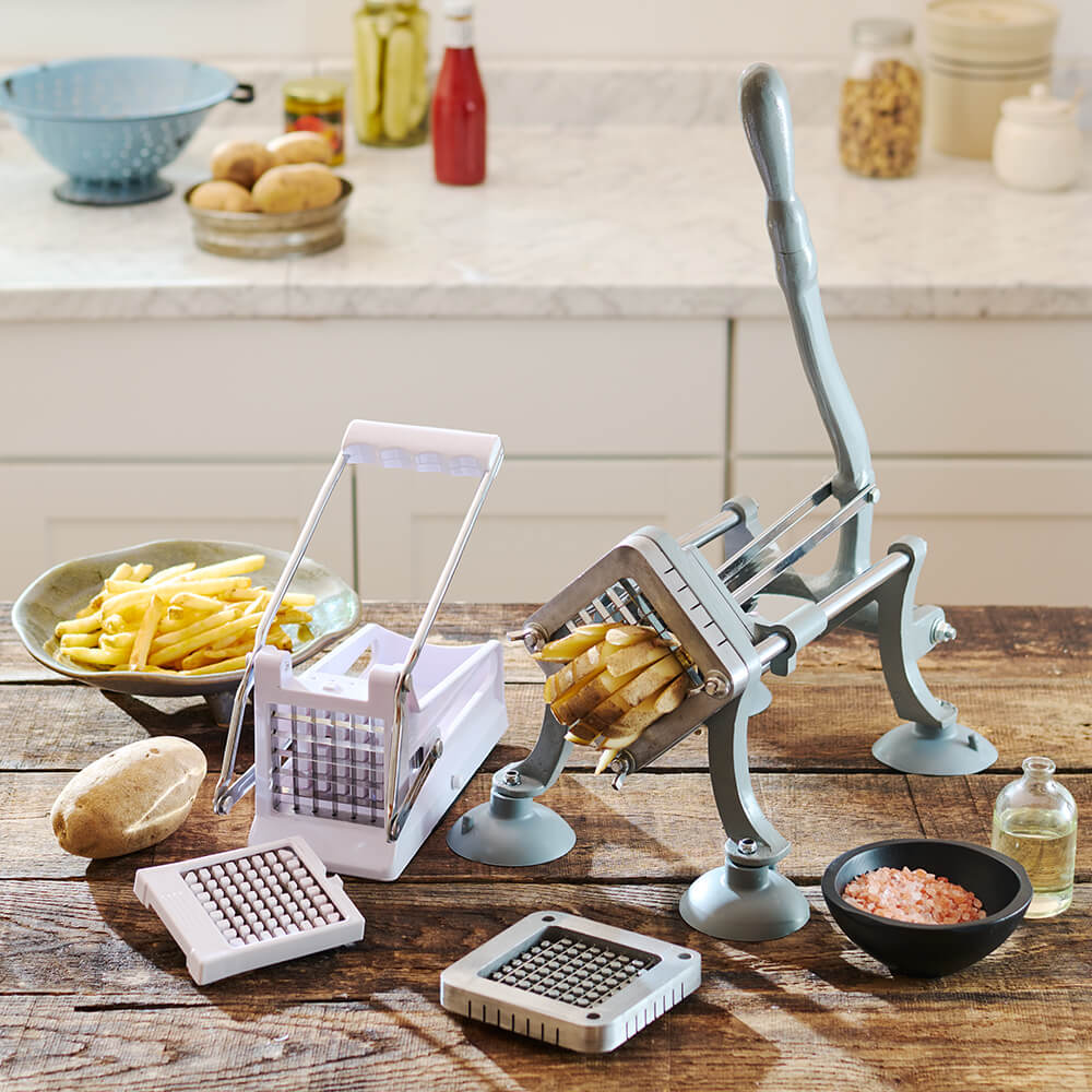Two French Fry Cutters on a wood table with russet potatoes